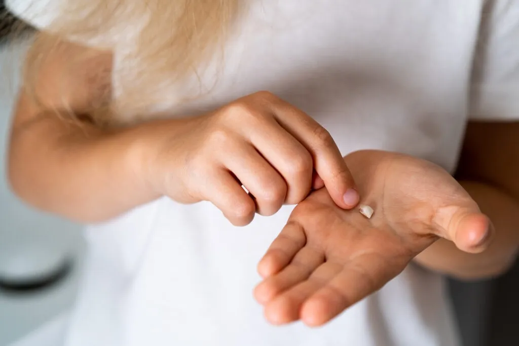 baby tooth on a child's palm close-up.